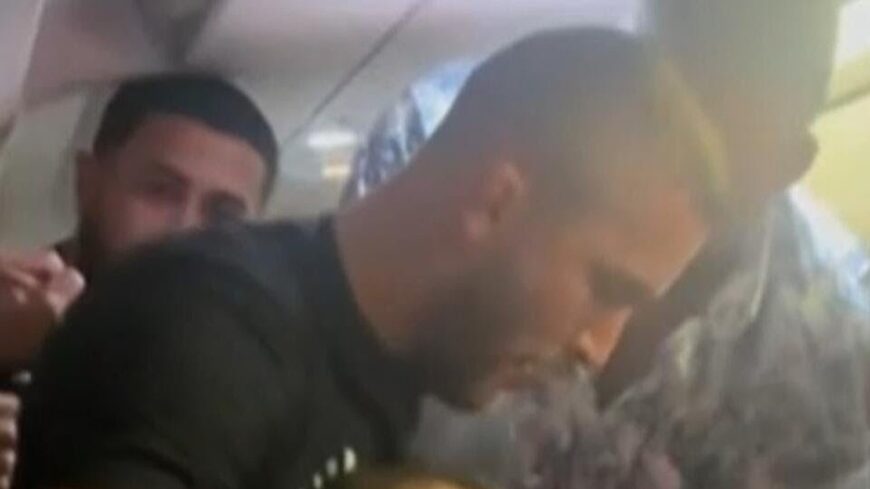 Josh Longood helps restrain Frontier Airlines passenger