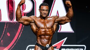 Niall Darwen posing onstage during the 2026 Classic Physique Olympia