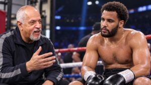 Russ Anber speaks beside an exhausted Moses Itauma in a boxing ring